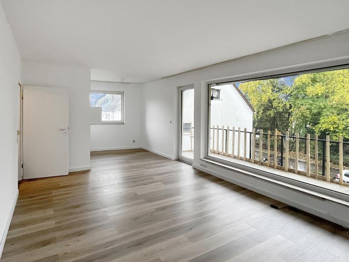 Appartamento ristrutturato e luminoso di 2,5 locali con cucina componibile, posto auto e ampio balcone vicino all’ALDI Campus – Wohnzimmer