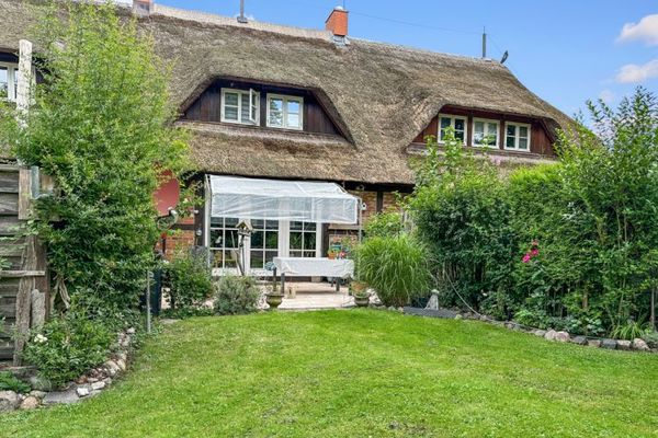 Thatched mid-terrace house with a large garden and garage