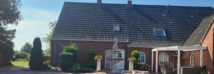 Exclusive detached house near Norddeich with pool, sauna, horse keeping – Ansicht Haus mit Brunnen