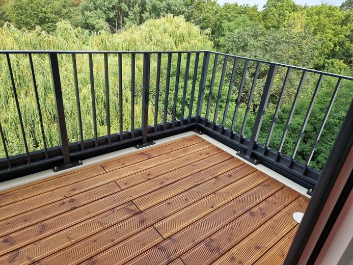 Neubau-Eigentumswohnung mit direkter Sicht auf einen kleinen See im Quartier HUGOS – Balkon