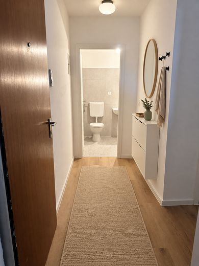 Investimento immobiliare ristrutturato di 2 locali senza provvigione con posto auto interrato | 6 % di rendimento lordo da locazione – Eingang (KI-Visual.)