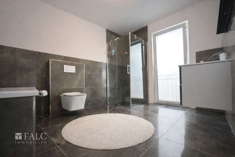 "Stilvolles Badezimmer mit Badewanne, Dusche und exklusiver Fliesengestaltung."