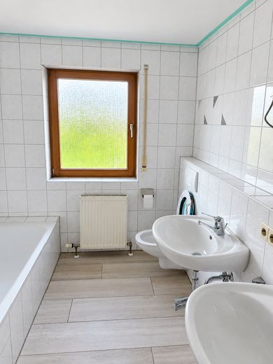Tanto spazio su 96 m²: appartamento al piano superiore con 4 locali, balcone, cucina componibile e garage – Bad mit Wanne und Dusche