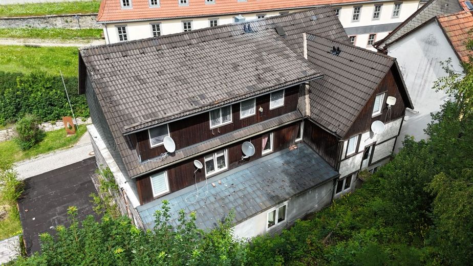 Exzellente Kapitalanlage mit Historie und stabiler Rendite: Vollvermietetes Mehrfamilienhaus in 96528 Frankenblick-Rauenstein! – Luftaufnahme Rückansicht Gebäude