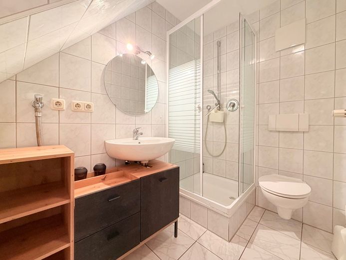 Renoviertes Einfamilienhaus mit Balkon, Carport und flexiblen Nutzungsmöglichkeiten – WC mit Dusche zur Nutzfläche im EG