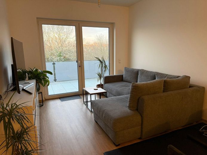Schöne 2-Zimmer Wohnung mit Balkon im Neubau – Blick ins Wohnzimmer u. Balkon