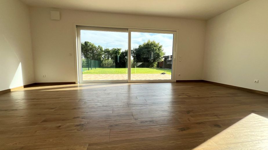 Ruhe mit Blick über Felder: Exklusives wohngesundes Plusenergie-Doppelhaus, S-Bahn fußläufig – Wohnzimmer mit Gartenblick
