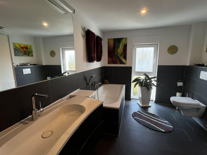 Maison individuelle économe en énergie avec jardin orienté au sud, cheminée, cuisine haut de gamme et garage double – Hauptbad