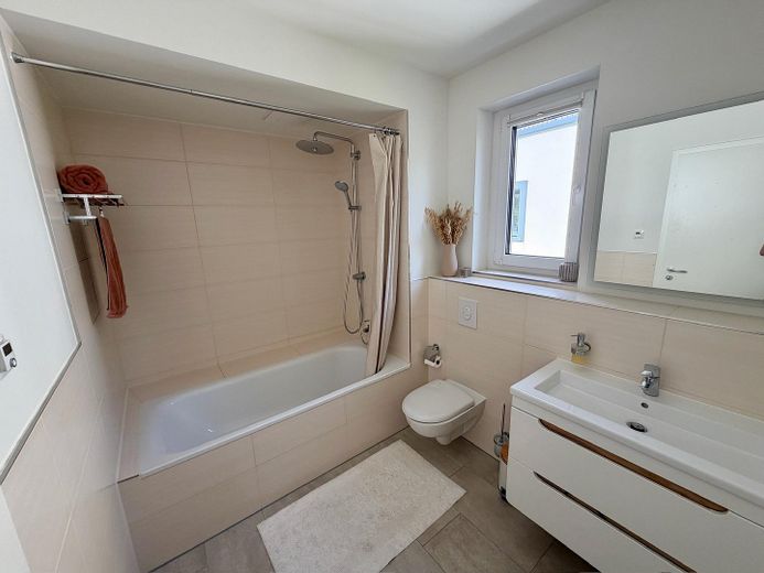 Sin comisión: Moderno apartamento de 4 habitaciones con balcón orientado al oeste y plaza de garaje subterránea con posibilidad de carga – Badezimmer