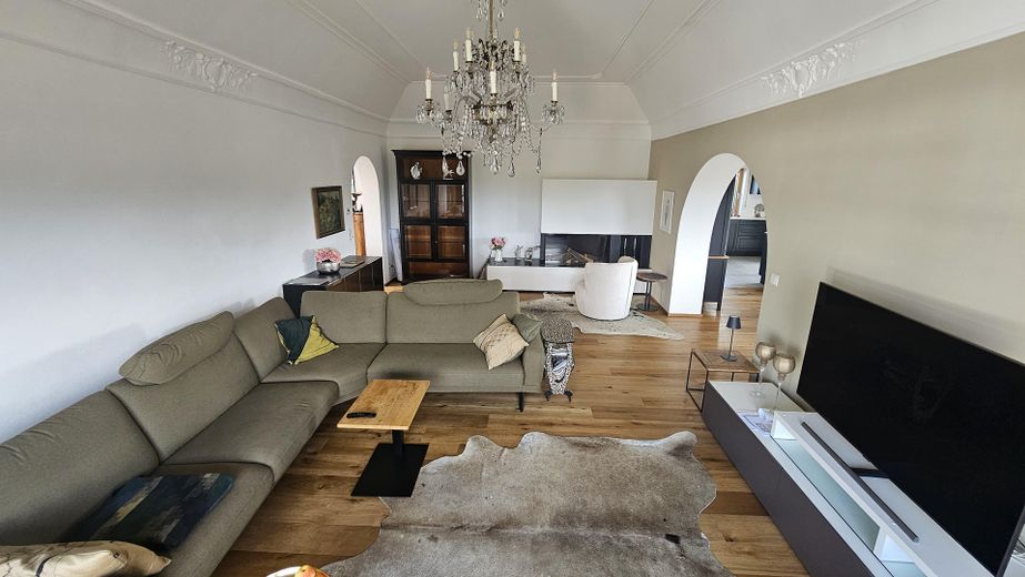 Exklusives Penthouse mit Alpenpanorama, XXL-Terrasse und Privataufzug – Wohnzimmer Blick auf Gas-Kamin