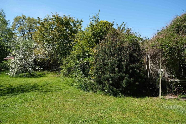 Grundstück mit Steinbungalow – Wiese mit Terassenecke