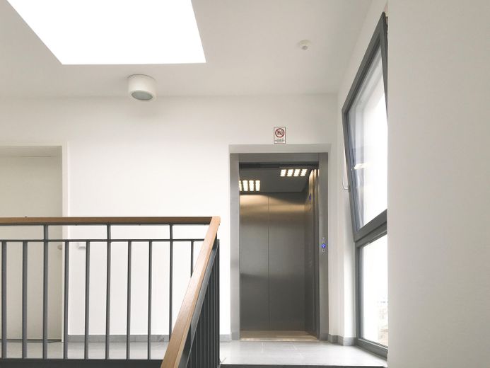 Skyline manzaralı, kapalı balkonlu, ankastre mutfaklı ve kapalı otoparklı aydınlık 2 odalı daire, Frankfurt-Riedberg – Treppenhaus mit Aufzug