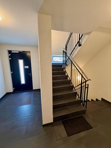 Sin comisión: Moderno apartamento de 4 habitaciones con balcón orientado al oeste y plaza de garaje subterránea con posibilidad de carga – Treppenhaus