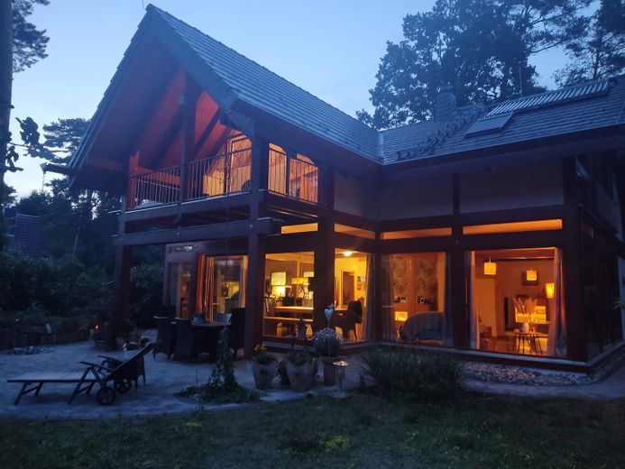 Lichtdurchflutete, energieeffiziente Villa aus Holz, Glas und Stein – Südseite beleuchtet