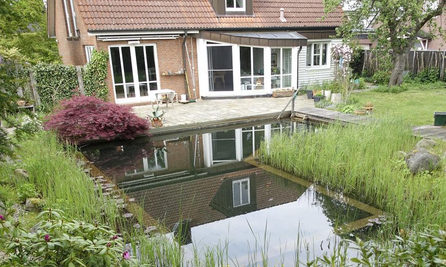 Lichtdurchflutetes Architektenhaus mit Schwimmteich – Gartenansicht mit Schwimmteich