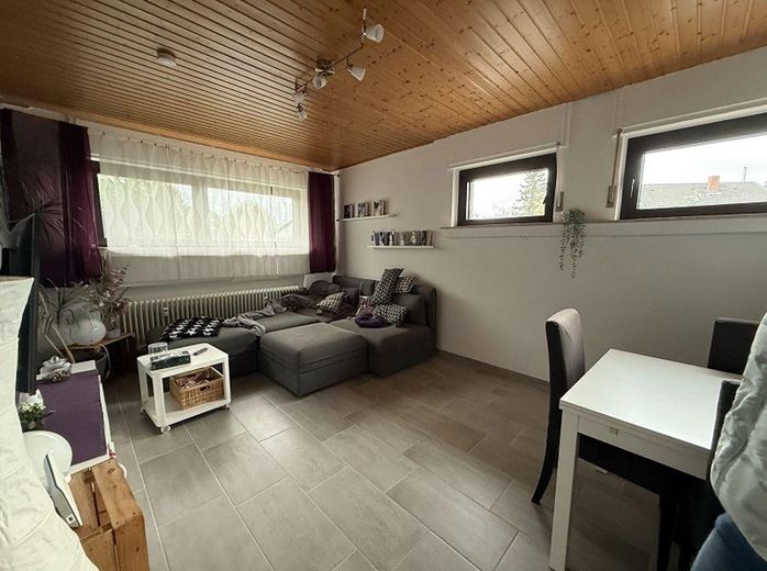 Vielseitiges Mehrfamilienhaus mit 3 Einheiten & attraktivem Baugrundstück – Wohnzimmer KG