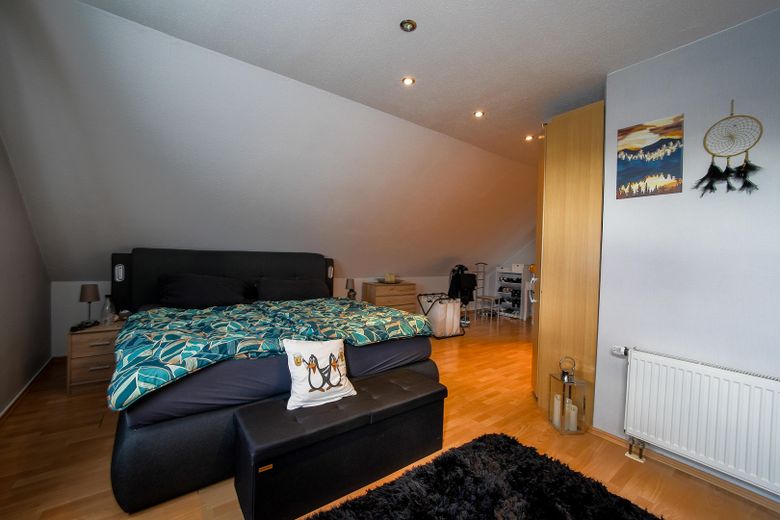 Außergewöhnliche 2-Zimmer-Dachgeschosswohnung mit Kamin, Vollbad, Balkon & ausgebautem Dachboden – Schlafzimmer_Bild1