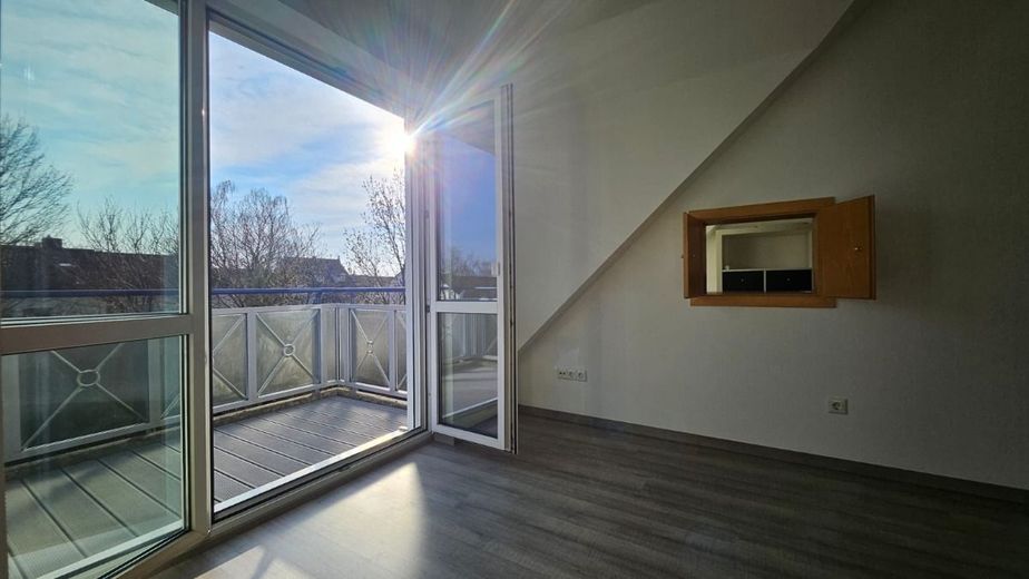 Helle 2-Zimmer-Dachgeschosswohnung mit Galerie und Balkon in ruhiger Lage in Hallbergmoos – Blick aus dem Wohnzimmer über den Balkon ins Freie