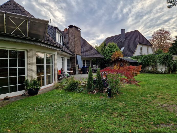 Freistehendes, individuelles  Architektenhaus mit separat gelegener Einliegerwohnung – Gartenansicht mit Aussenkamin