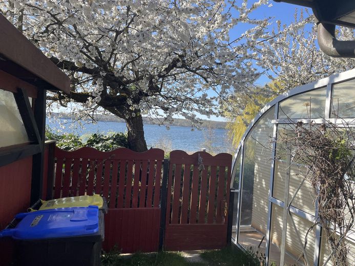 Idyllisches Haus am See mit Bootsanleger – Sicht vom Carport zum See