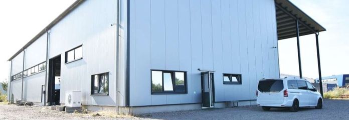 Ubicación empresarial orientada al futuro: nave industrial inundada de luz con zona de oficinas y área social