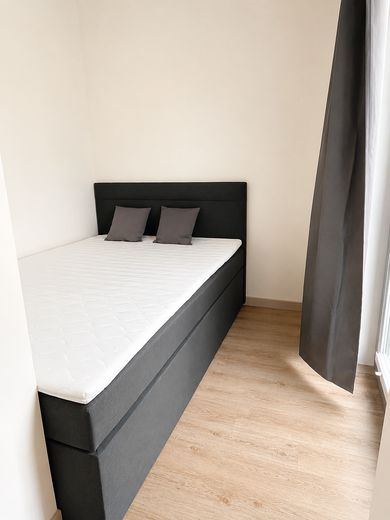 Möbliertes & modernes Apartment mit All-In-Miete – Schlafbereich mit Bett 