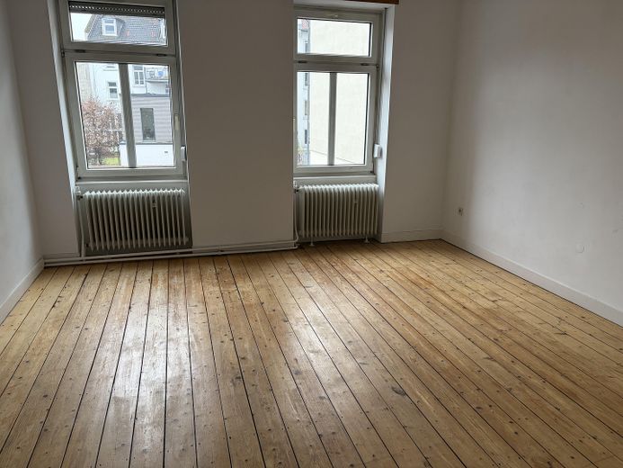 Gepflegter Altbau mit 5 Parteien, Dielen & 3 m Raumhöhe in Toplage mit Entwicklungspotential – 1. OG Wohnzimmer