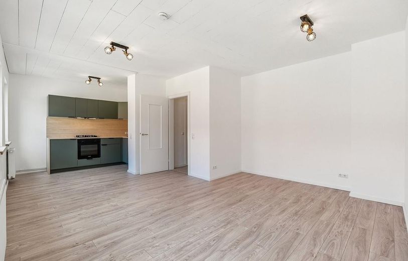Bezugsfertiges City-Apartment – saniert, modern und zentral – Wohnzimmer mit Küchenzeile