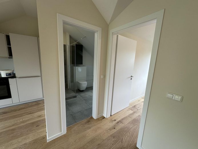 Provisionsfreie Neubau-Dachgeschosswohnung–Erstbezug, hochwert. Ausstattung, 5 Min. Bhf Köpenick – Blick ins Bad und Schlafzimmer
