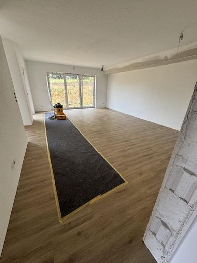 Hochwertige 3-Zimmer-Gartenwohnung mit Südterrasse, Designküche & Blick ins Grüne – Wohnbereich mit Designboden