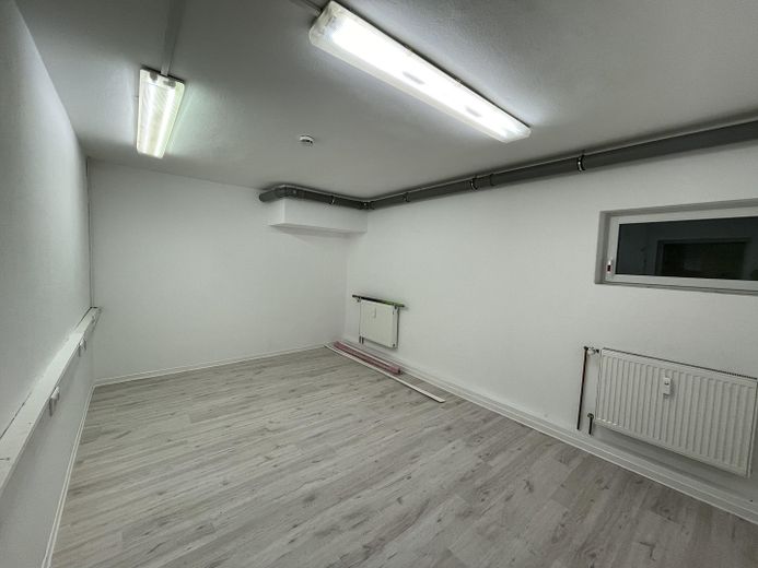 Zentrale Ladenfläche mit hoher Sichtbarkeit, großer Schaufensterfront und Stellplätzen – Büro UG 2