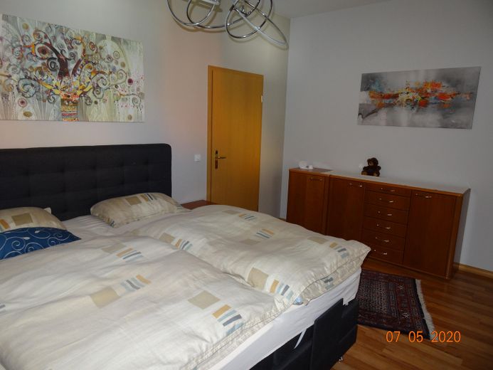 Ihr Zuhause auf Zeit: Helle 2-Zi.-Wohnung mit hochwertiger Ausstattung & Balkon – Schlafzimmer mit Bett/Kommode