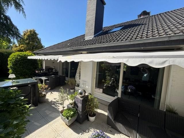 Exklusiver Walmdachbungalow vor den Toren Hamburgs, Bönningstedt, provisionsfrei – Terrasse Südseite mit Kamin