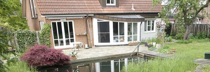 Lichtdurchflutetes Architektenhaus mit Schwimmteich – Gartenansicht mit Schwimmteich