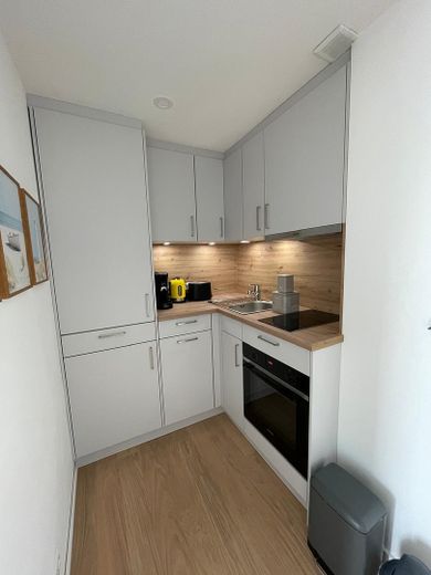 Above the rooftops of Norderney: Stylish 2-room apartment with sunny balcony – Moderne Einbauküche