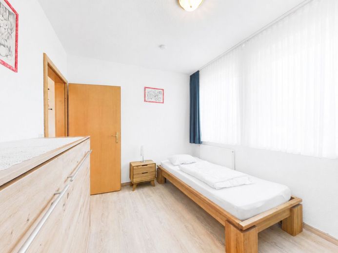 Urlaub beginnt hier - helle Ferien-Wohnung mit 
Balkon &amp; Sauna an der Nordsee in Dorum-Neufeld – Schlafzimmer mit platzsparendem Schrankbett
