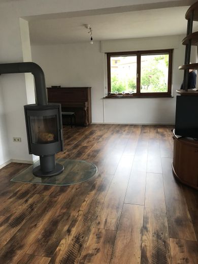 Freistehendes Einfamilienhaus mit Photovoltaikanlage auf sonnigem Grundstück in Berlin-Wittenau – Wohnzimmer mit Kaminofen