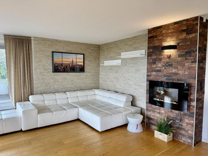 Penthouse mit großer Dachterrasse, Panoramablick & privater Sauna – Wohnbereich mit Kaminwand
