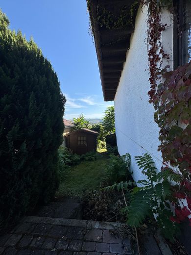 Großzügiges Einfamilienhaus mit Fernblick – Seitenansicht mit Gartenhütte
