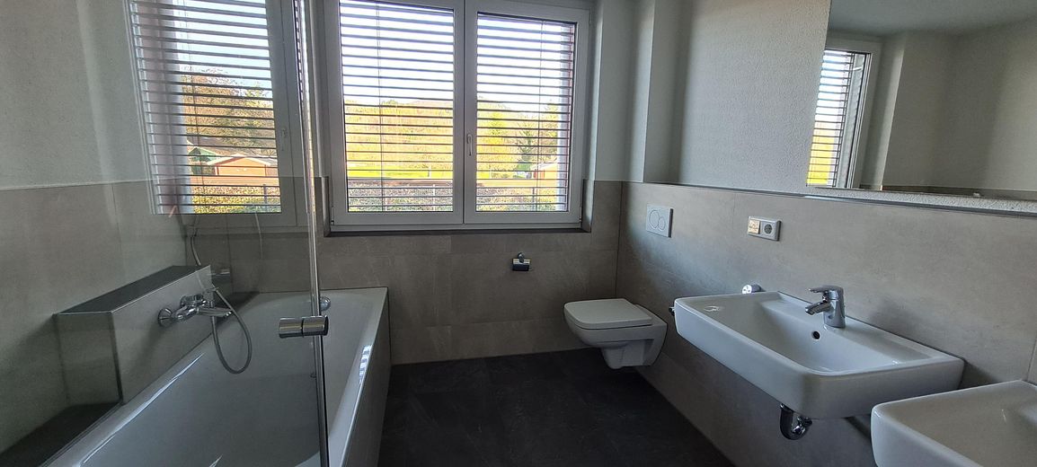 1. piętro nowoczesne mieszkanie 3,5-pokojowe z windą, zabudowaną kuchnią, zadaszonym balkonem, pomieszczeniem gospodarczym i WC dla gości – Bad
