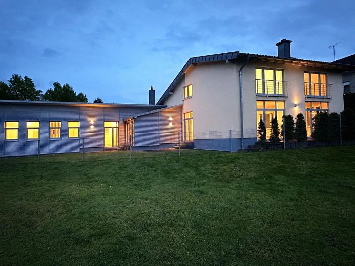 Modernes Wohnhaus mit separater Gewerbeeinheit in ruhiger Citylage – Rückseite Abendstimmung