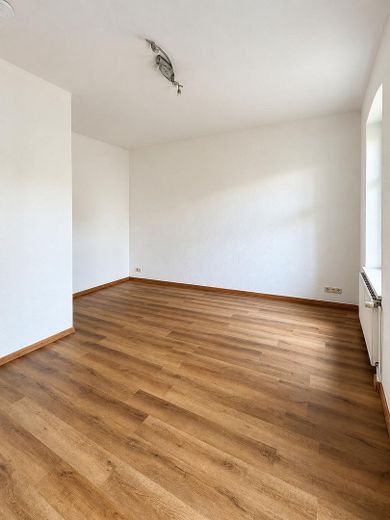 Luminoso appartamento d’epoca con 2 locali e ampio balcone esposto a sud in posizione centrale – Wohnzimmer mit Holzboden
